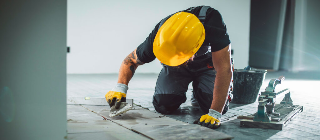 Contractor installing a popular type of durable tile flooring